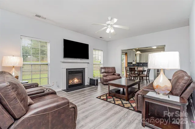 a living room with furniture a fireplace and a flat screen tv