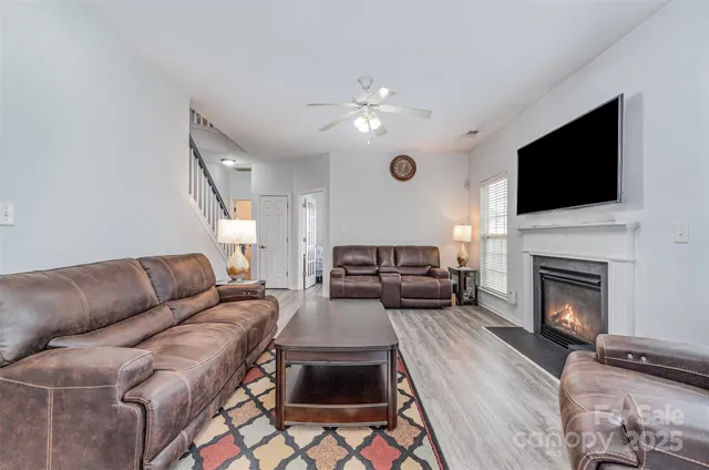 a living room with furniture a fireplace and a flat screen tv