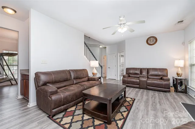 a living room with furniture and a wooden floor