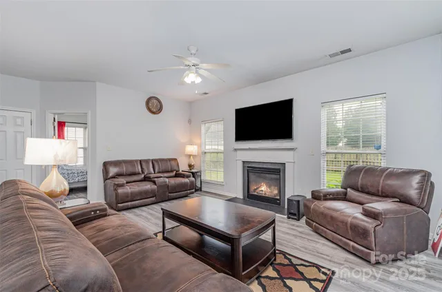 a living room with furniture a fireplace and a flat screen tv