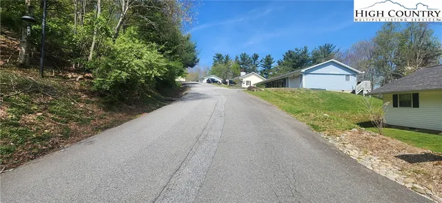 a view of a street with a house in the background