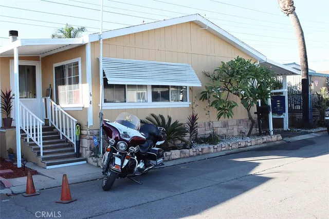 a view of a house with a small yard and wooden fence
