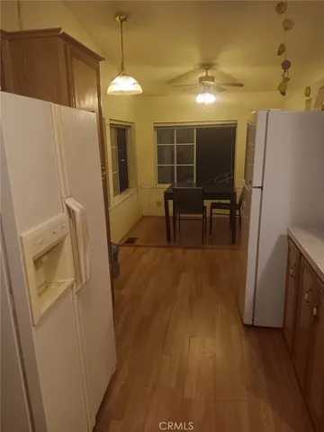 a kitchen with refrigerator a microwave a sink and wooden floor