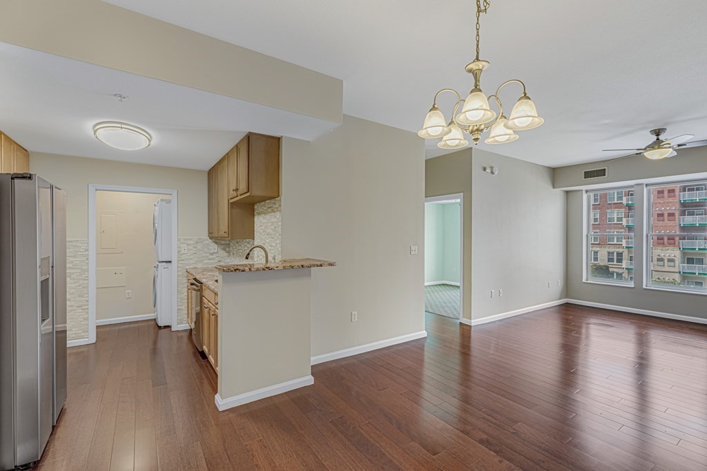 a view of a kitchen with a sink dishwasher a refrigerator and wooden floor