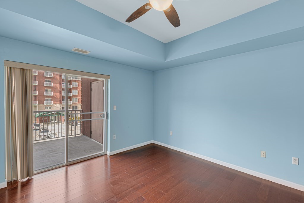 38 Village Road, Unit 305 Middleton, MA 01949 - Photo 12 of 25 an empty room with wooden floor and windows