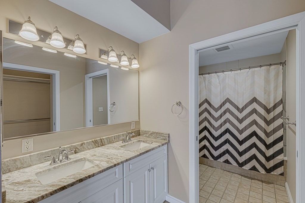 38 Village Road, Unit 305 Middleton, MA 01949 - Photo 17 of 25 a bathroom with a granite countertop sink a light fixture and a mirror