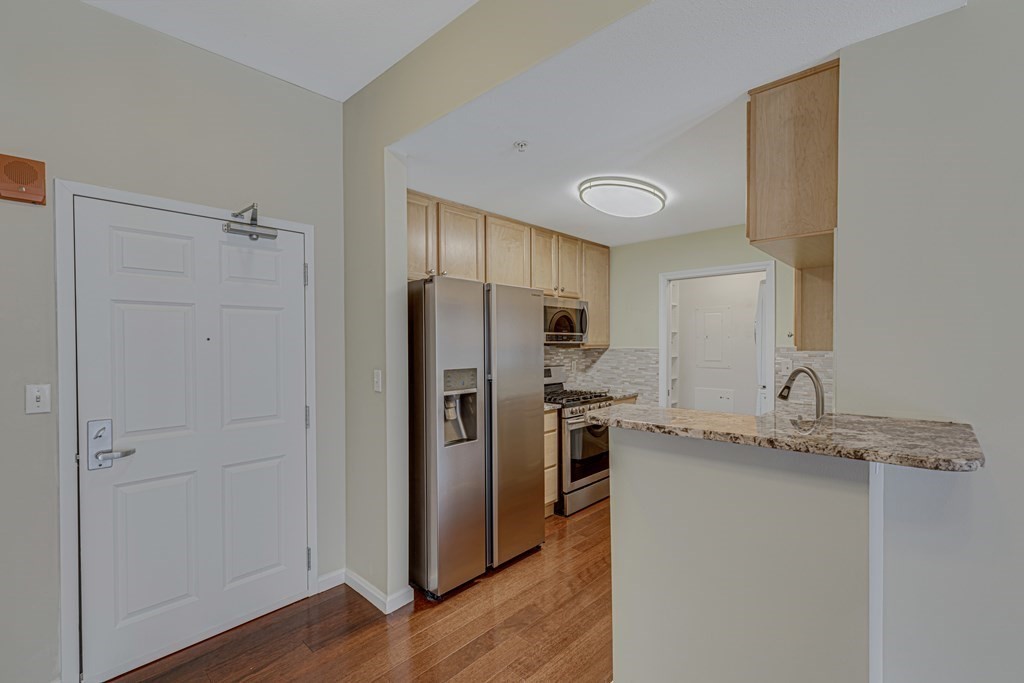 38 Village Road, Unit 305 Middleton, MA 01949 - Photo 2 of 25 a kitchen with stainless steel appliances granite countertop a refrigerator and a stove