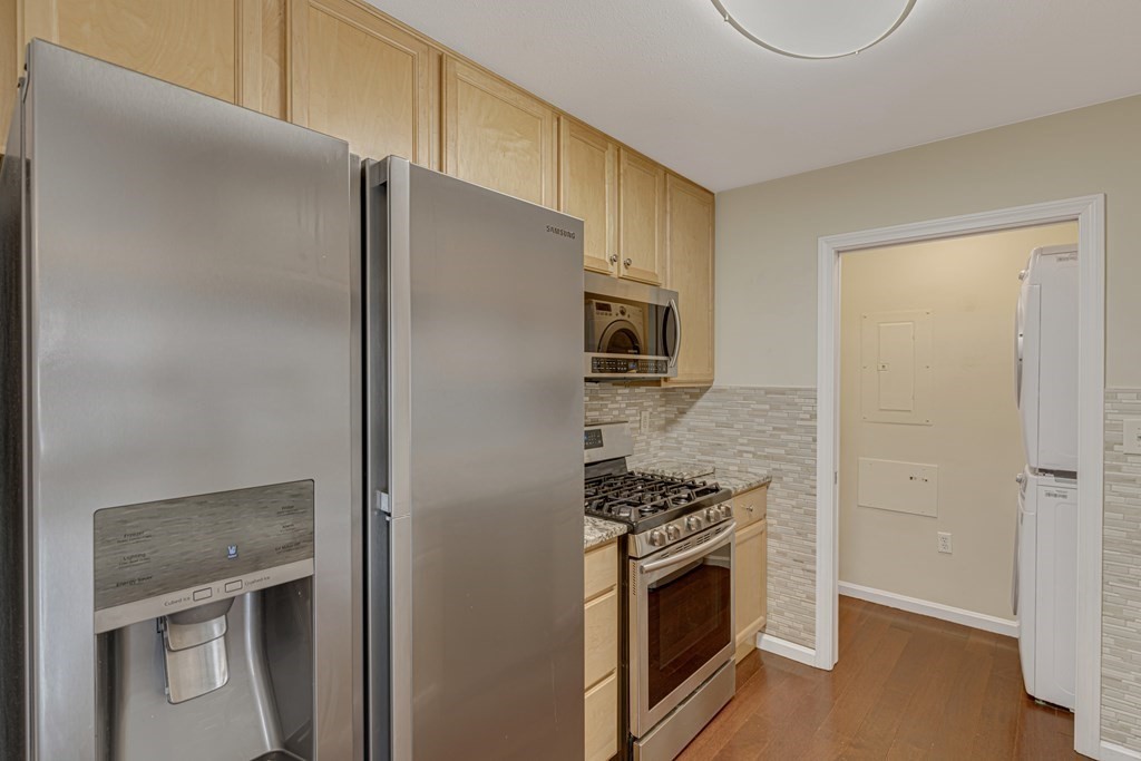 38 Village Road, Unit 305 Middleton, MA 01949 - Photo 3 of 25 a kitchen with stainless steel appliances a refrigerator a stove and a sink