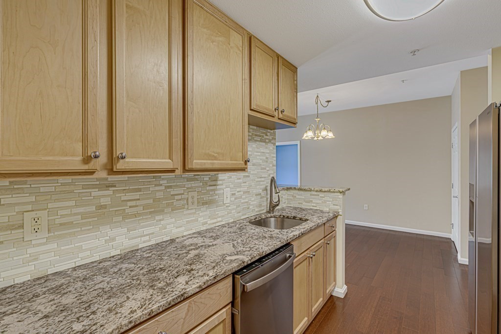 38 Village Road, Unit 305 Middleton, MA 01949 - Photo 7 of 25 a kitchen with granite countertop cabinets and sink