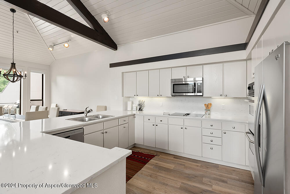 3904 Brush Creek Road, Unit 11 Snowmass Village, CO 81615 - Photo 12 of 25 a kitchen with granite countertop a sink stainless steel appliances and white cabinets