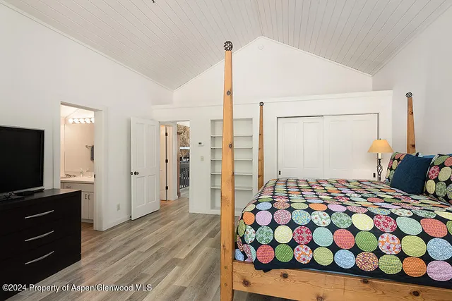 a bedroom with a bed and flat screen tv