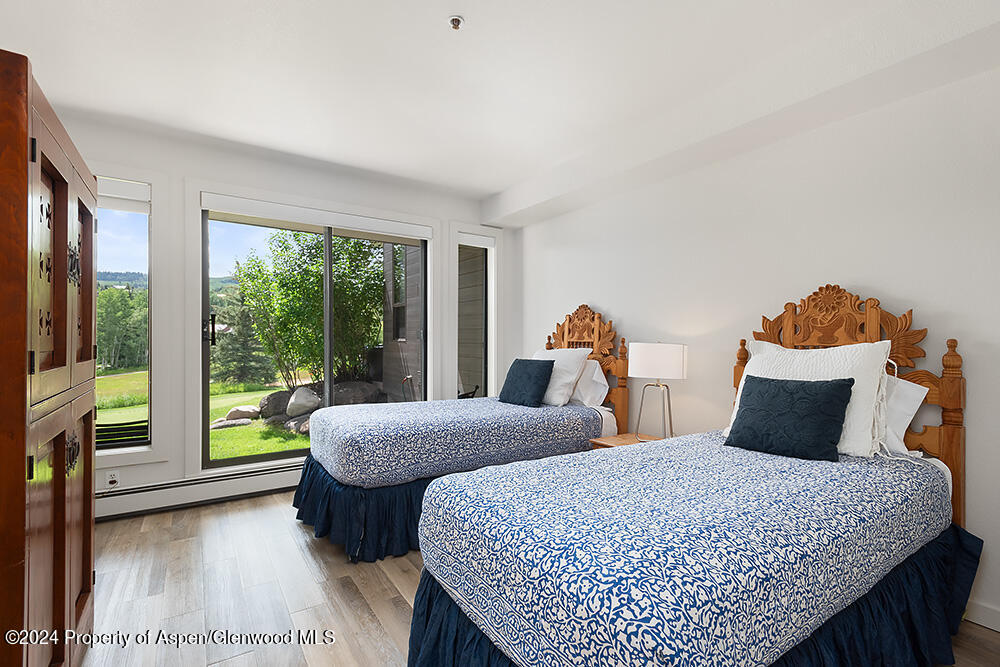 3904 Brush Creek Road, Unit 11 Snowmass Village, CO 81615 - Photo 20 of 25 a bedroom with two beds and large window