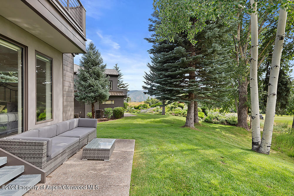 3904 Brush Creek Road, Unit 11 Snowmass Village, CO 81615 - Photo 4 of 25 a view of a backyard with couches plants and large tree