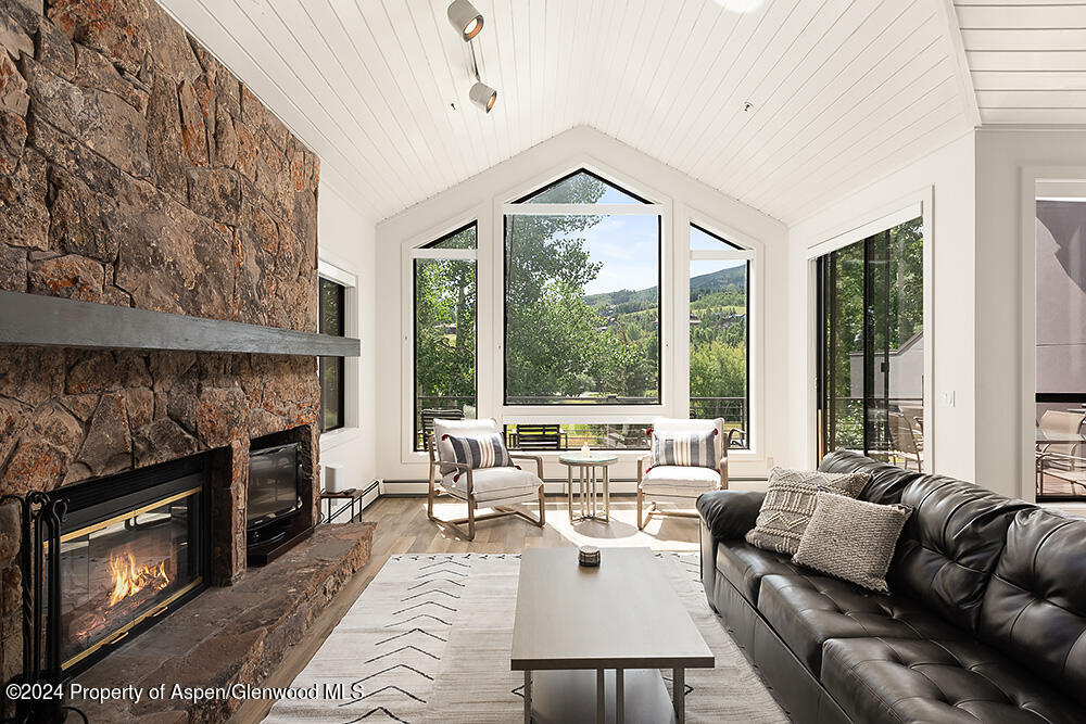 3904 Brush Creek Road, Unit 11 Snowmass Village, CO 81615 - Photo 6 of 25 a living room with furniture large window and fireplace