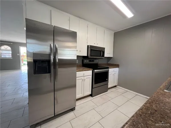a kitchen with stainless steel appliances a refrigerator and a stove top oven