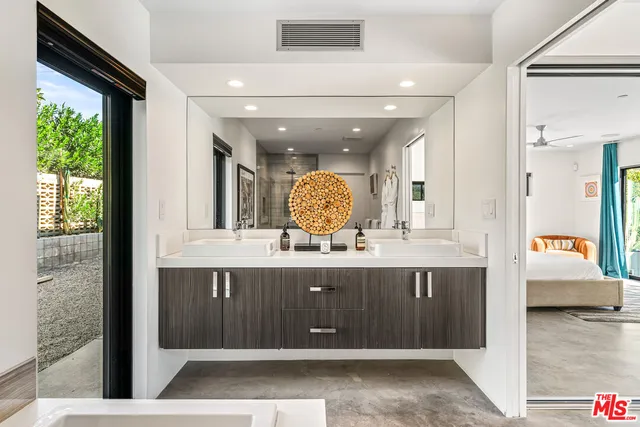 a living room with patio furniture and a potted plant