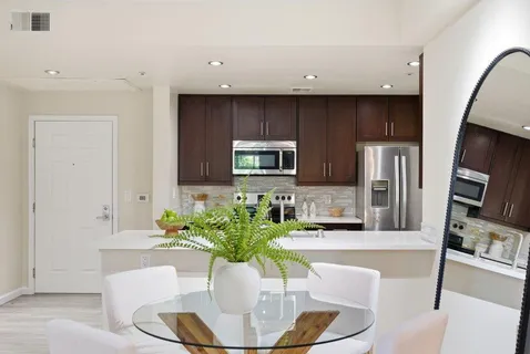 a kitchen with stainless steel appliances granite countertop a refrigerator a sink dishwasher a stove and a microwave oven on granite countertops