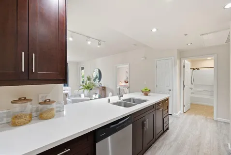 a kitchen with sink a microwave and cabinets