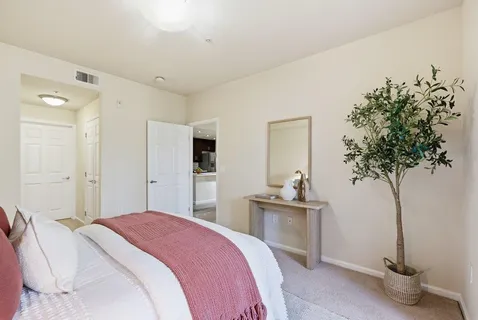 a bedroom with a large bed and a chandelier