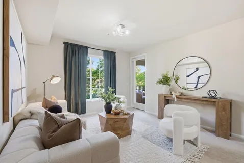 a living room with furniture a potted plant and a window