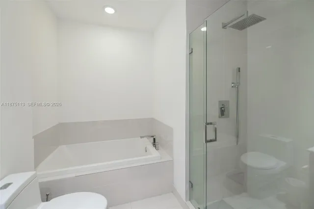 a white bath tub sitting next to a toilet