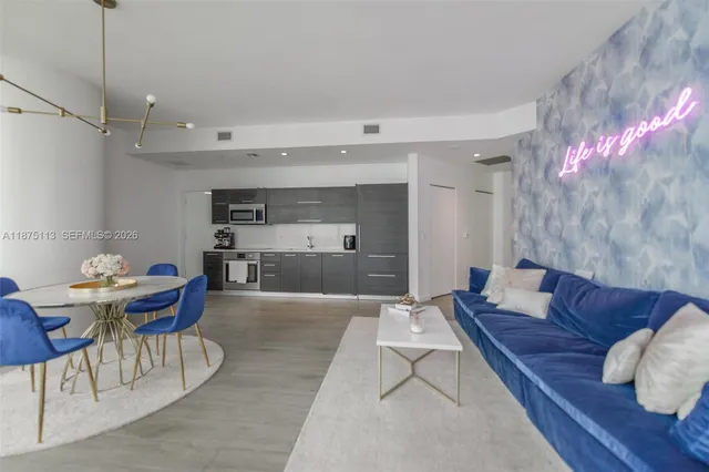 a living room with furniture and a kitchen view
