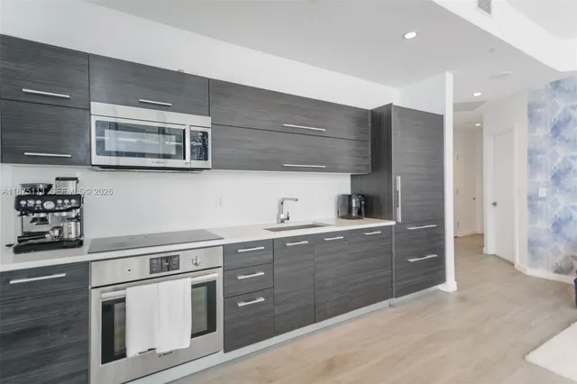 a kitchen with stainless steel appliances granite countertop a sink and a stove
