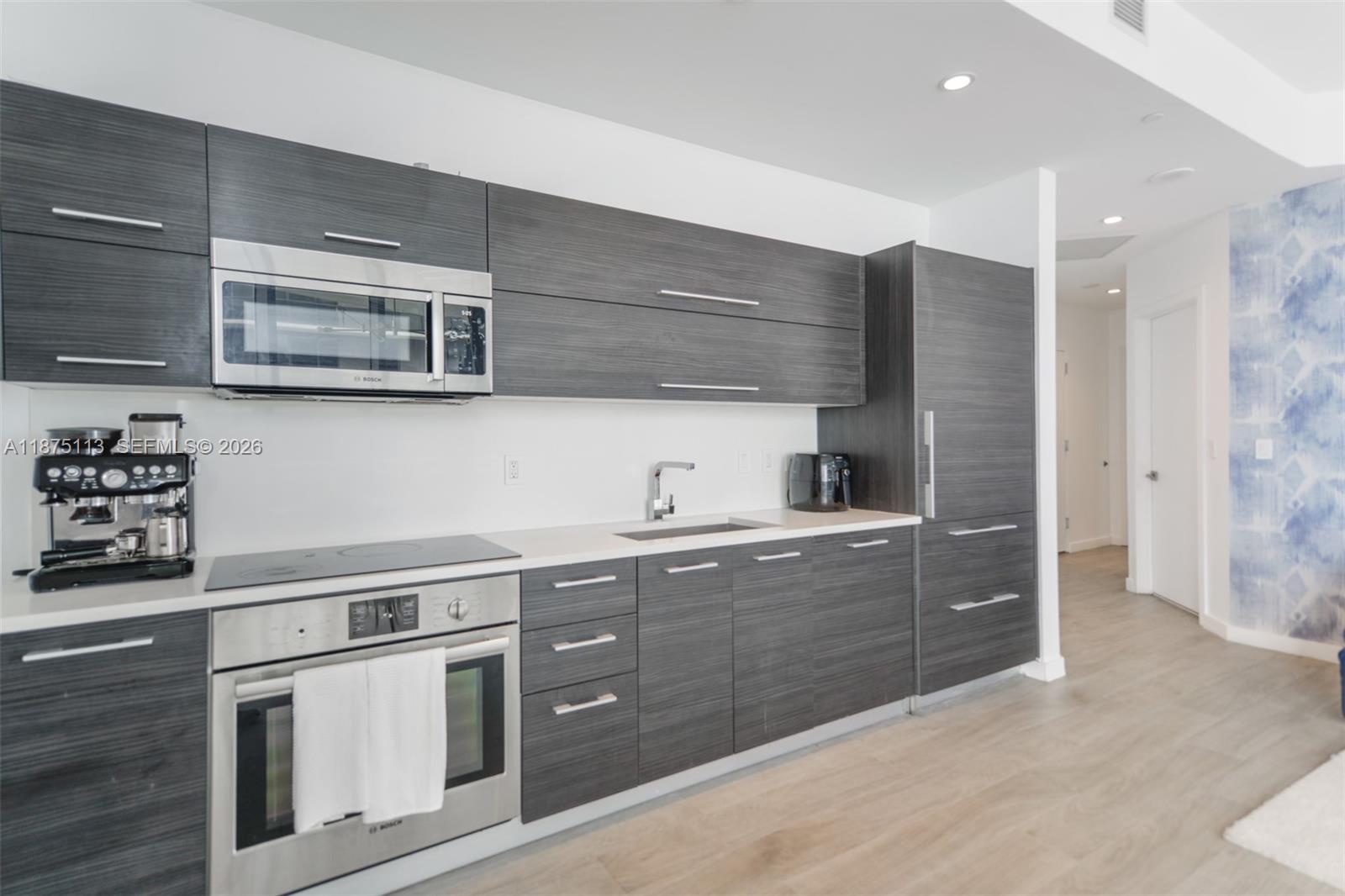 45 Southwest 9th Street, Unit 4108 Miami, FL 33130 - Photo 7 of 28 a kitchen with stainless steel appliances granite countertop a sink and a stove