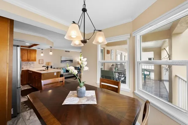 a view of a dining room and livingroom with furniture wooden floor a chandelier
