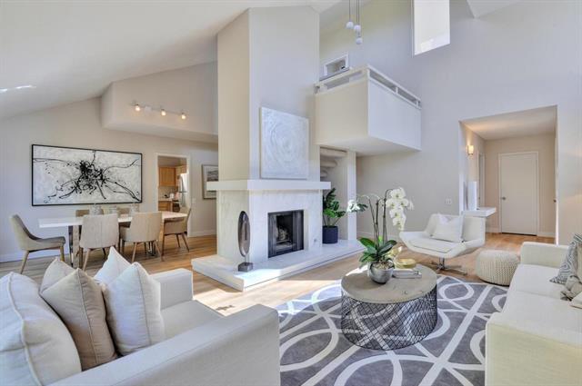 a living room with furniture a fireplace and a large mirror