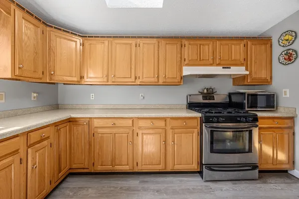 a kitchen with granite countertop cabinets stainless steel appliances and a window