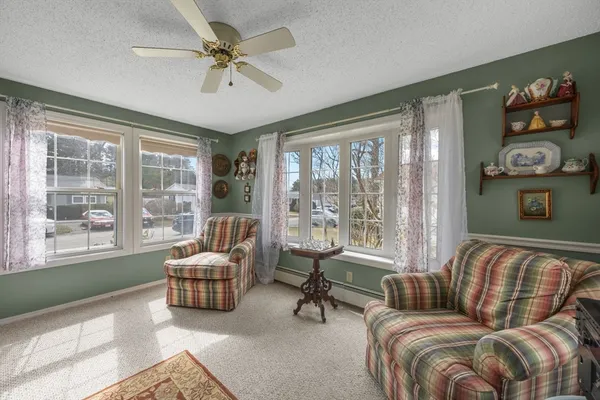 a living room with furniture and a large window with garden view