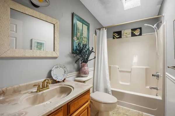 a bathroom with a granite countertop sink toilet and shower
