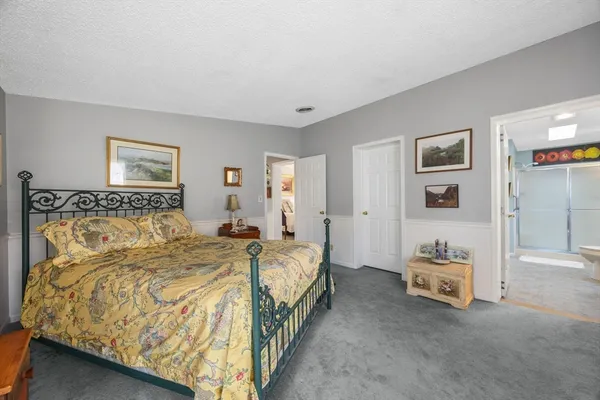 a spacious bedroom with a bed and a lamp