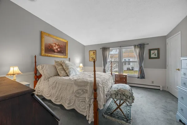 a bedroom with a bed and large windows