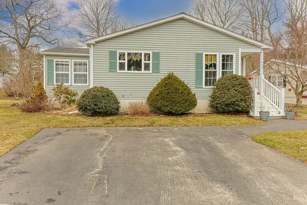 a view of a house with a yard and potted plants