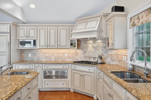 a kitchen with stainless steel appliances granite countertop a sink and a white cabinets