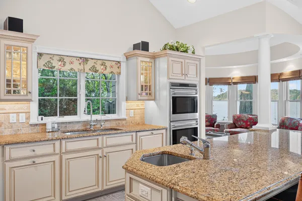 a dining room with wooden floor a chandelier a wooden table and chairs