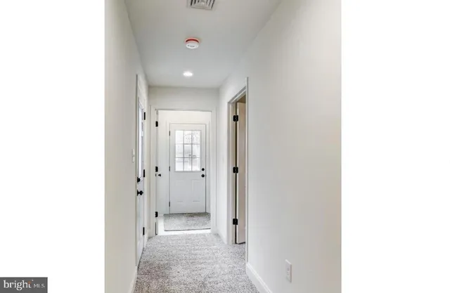 a view of a hallway with bathroom and shower