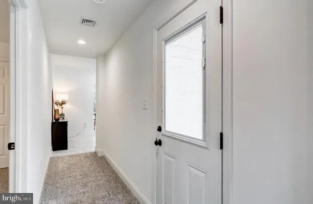 a view of a hallway with a door and couch