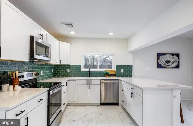 a kitchen with stainless steel appliances granite countertop a sink and dishwasher a stove top oven with white cabinets