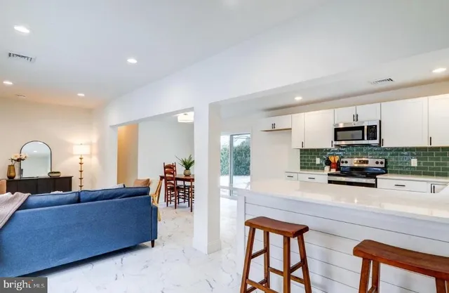 a living room with furniture and kitchen view
