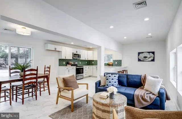 a living room with furniture kitchen view and a table