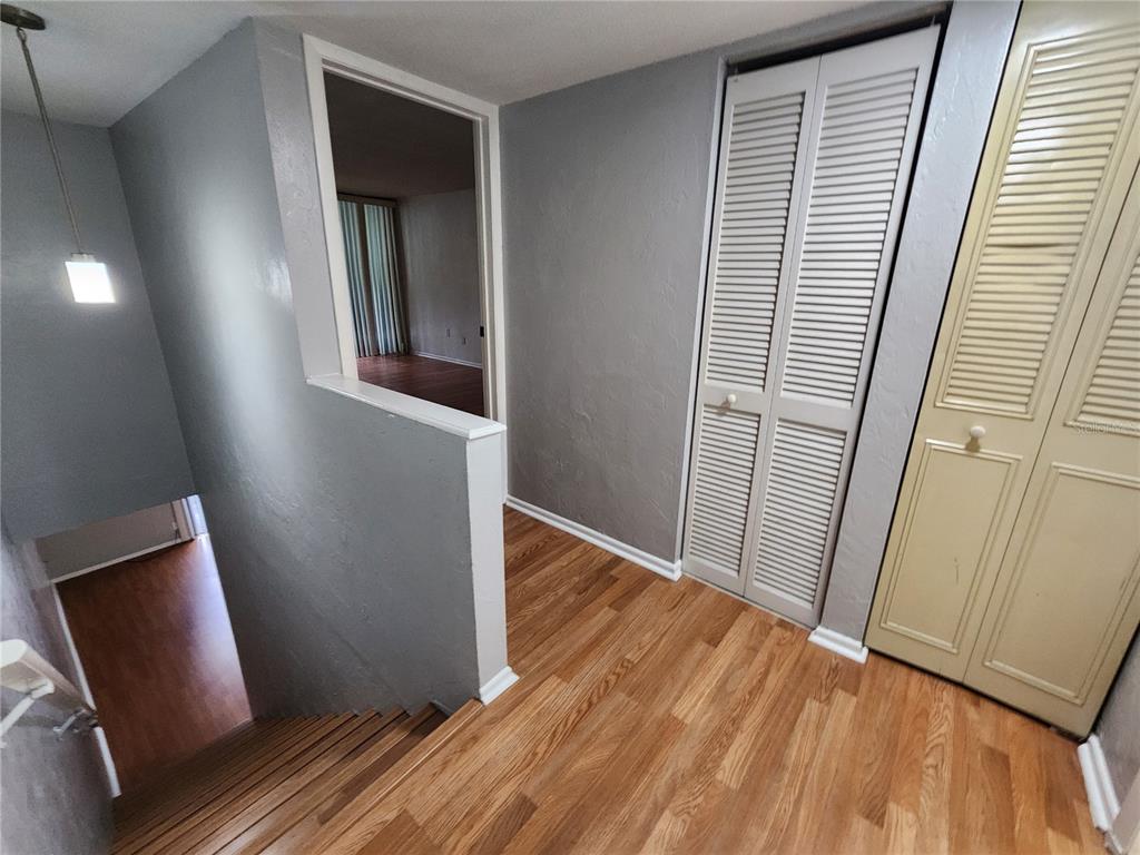 719 Southwest 75th Street, Unit 103 Gainesville, FL 32607 - Photo 13 of 28 a view of a hallway with wooden floor and staircase