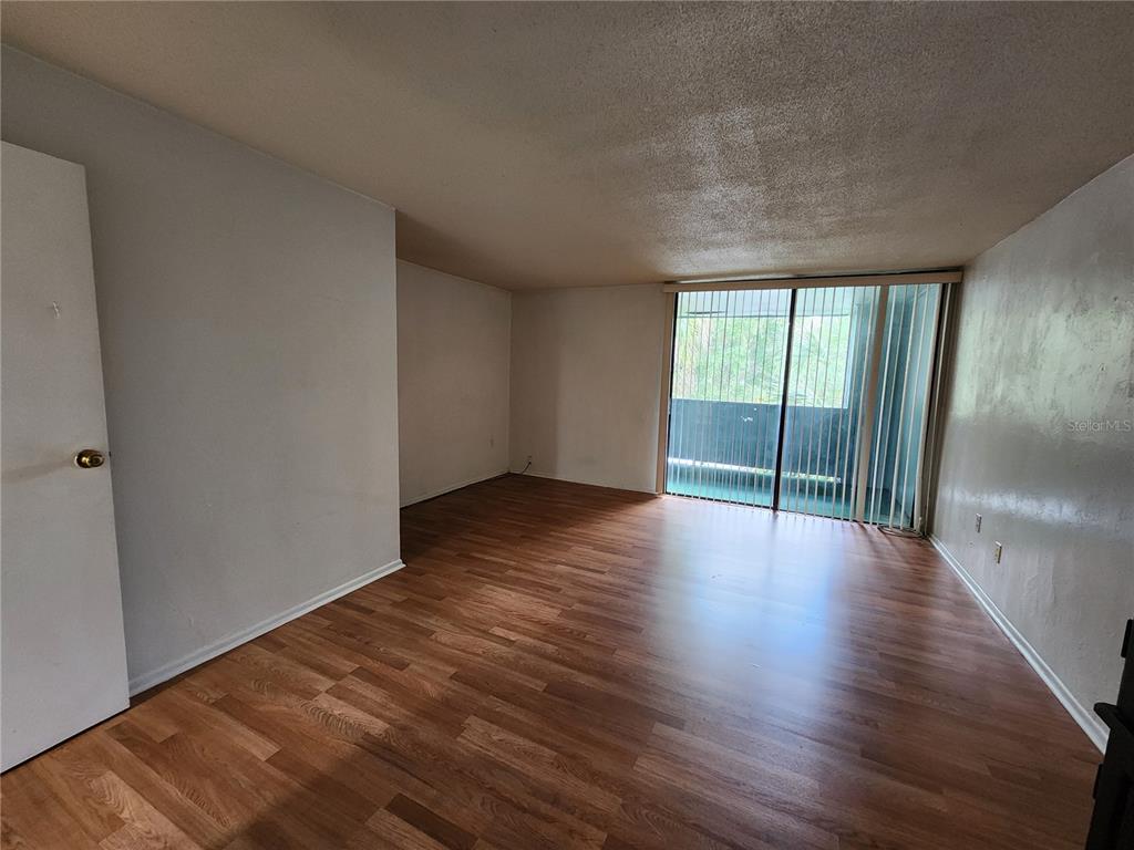 719 Southwest 75th Street, Unit 103 Gainesville, FL 32607 - Photo 18 of 28 a view of an empty room with wooden floor and a window