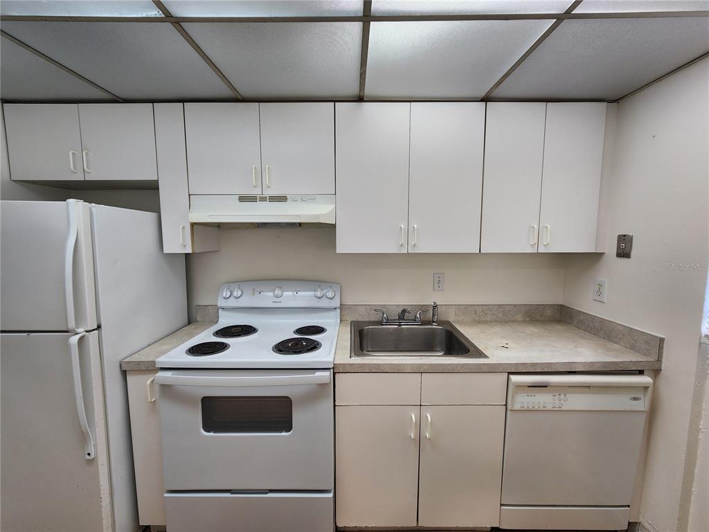 719 Southwest 75th Street, Unit 103 Gainesville, FL 32607 - Photo 22 of 28 a kitchen with white cabinets and white appliances