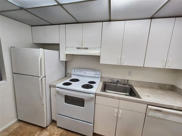 a kitchen with a refrigerator sink and cabinets