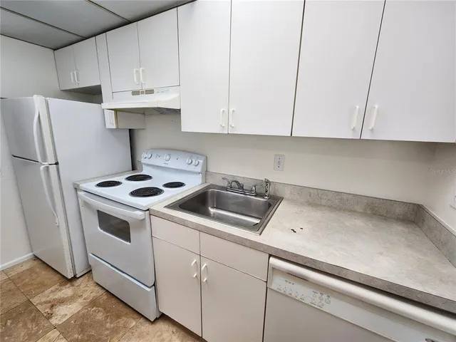 a kitchen with white cabinets and white appliances