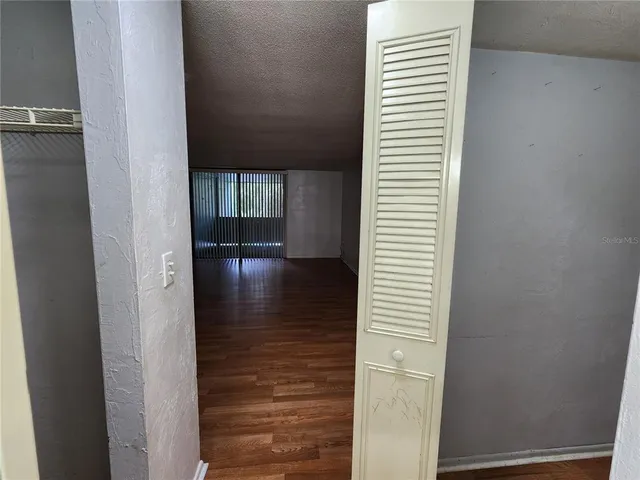 a view of a hallway with front door and wooden floor