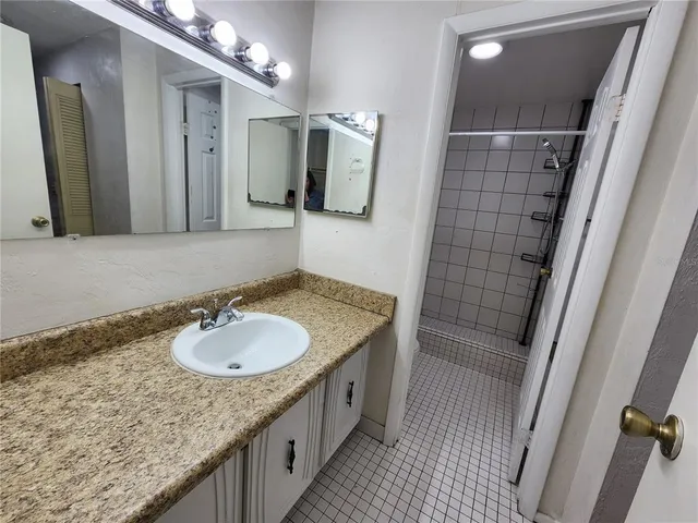 a bathroom with a granite countertop sink and a mirror